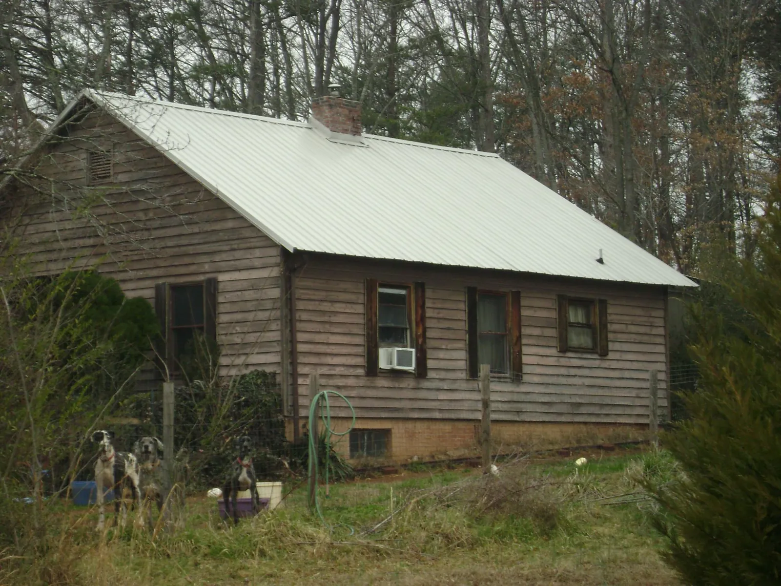 White metal roof on an old wood sided farmhouse, from a Metal Roof Installation job in Kissimmee
